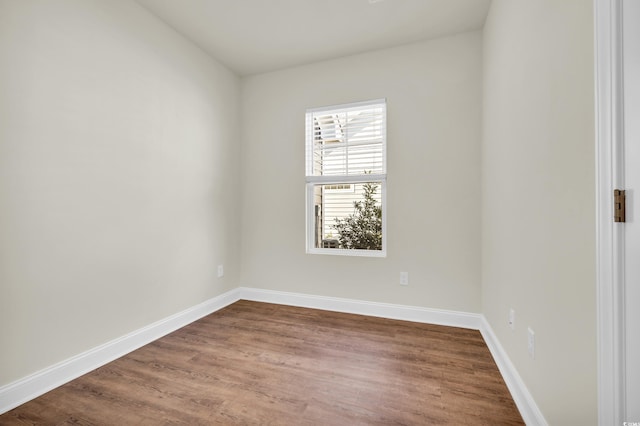 empty room featuring wood finished floors and baseboards