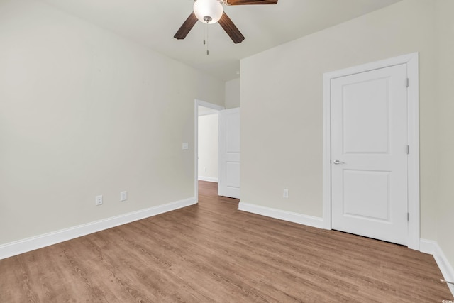 unfurnished bedroom featuring ceiling fan, light wood-type flooring, and baseboards