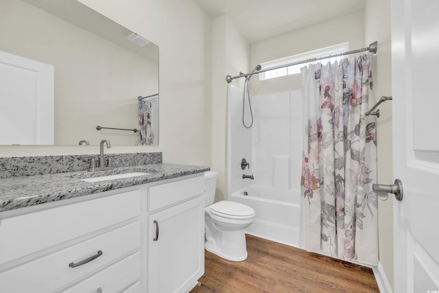 bathroom featuring toilet, shower / bath combo, wood finished floors, and vanity