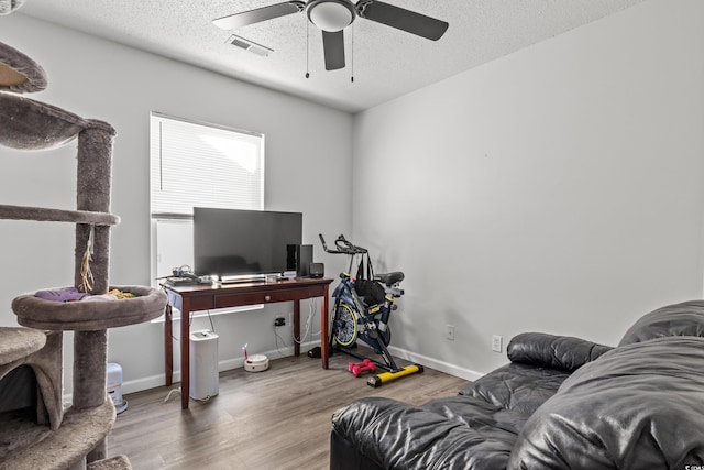 office with hardwood / wood-style flooring, ceiling fan, and a textured ceiling