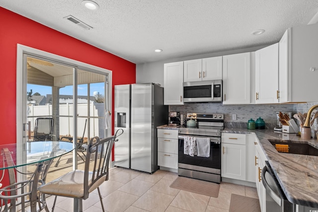 kitchen featuring light stone counters, sink, white cabinets, and appliances with stainless steel finishes