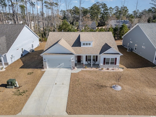 view of front of home featuring a garage, a front yard, and covered porch