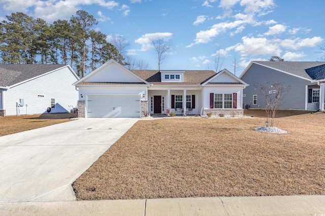 view of front of home featuring a garage, covered porch, and a front yard