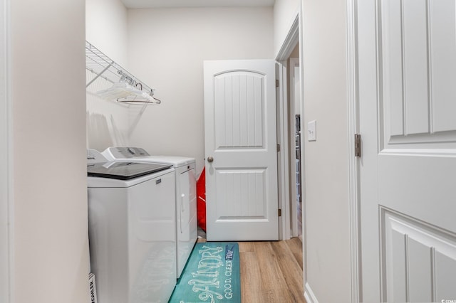 laundry room with independent washer and dryer and light wood-type flooring