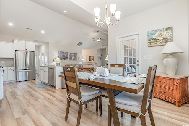 dining room with ceiling fan with notable chandelier, sink, vaulted ceiling, and light hardwood / wood-style flooring