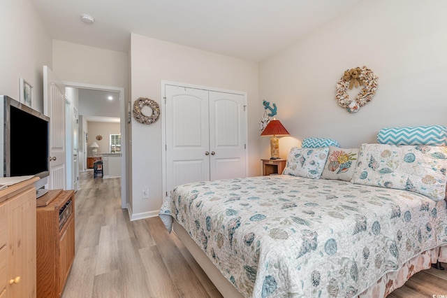 bedroom with light hardwood / wood-style floors and a closet