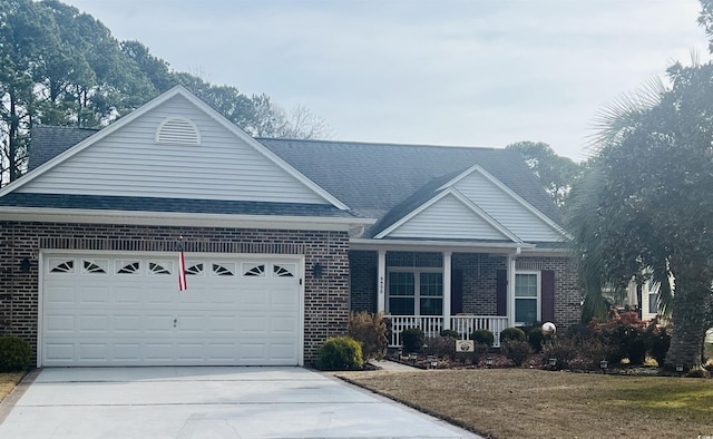 view of front of house featuring a porch, a garage, and a front yard