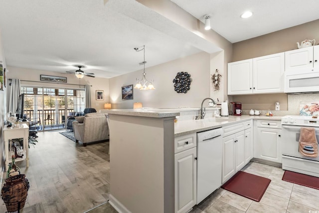 kitchen featuring sink, white cabinetry, kitchen peninsula, pendant lighting, and white appliances