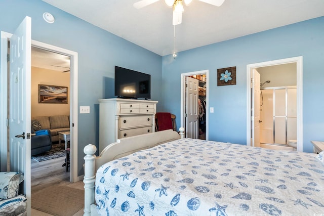 bedroom with a spacious closet, a closet, ceiling fan, and ensuite bathroom