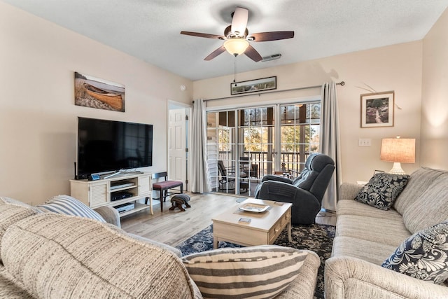 living room with wood-type flooring, a textured ceiling, and ceiling fan