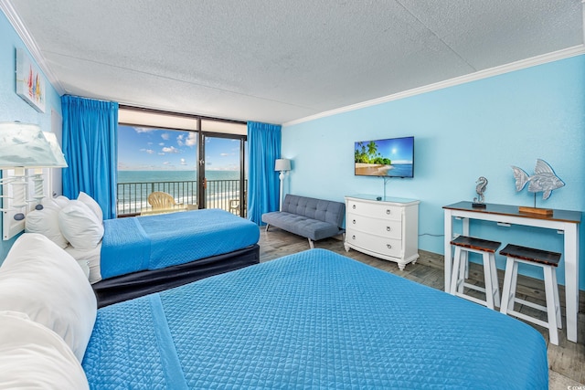 bedroom featuring crown molding, hardwood / wood-style floors, a textured ceiling, and access to outside