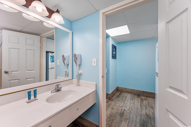 bathroom featuring a drop ceiling, sink, and wood-type flooring