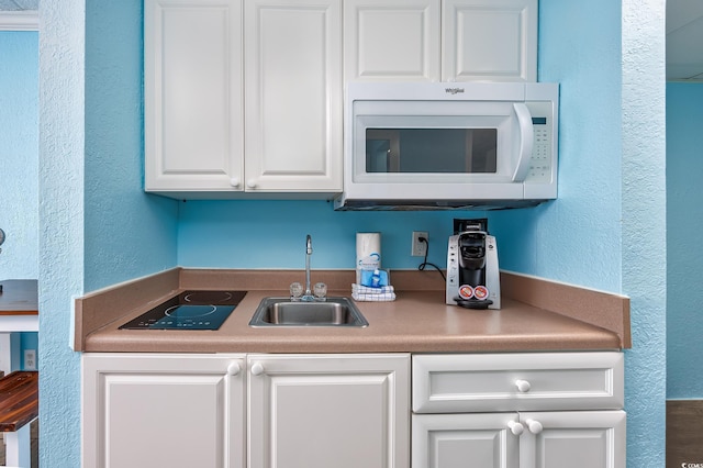 kitchen featuring sink and white cabinets