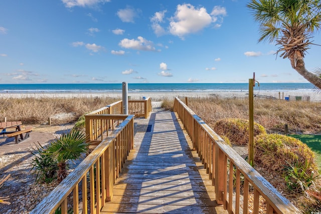 view of home's community with a water view and a beach view