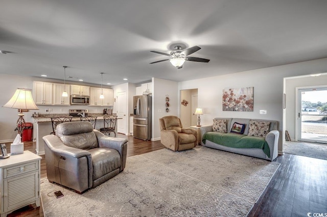 living room featuring hardwood / wood-style floors and ceiling fan