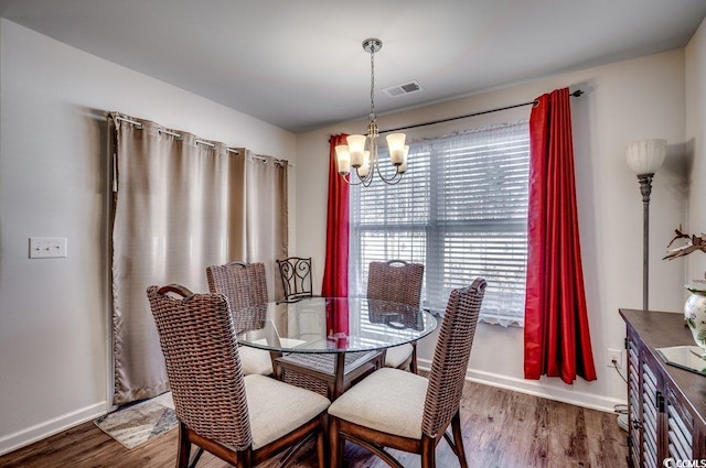 dining area featuring an inviting chandelier and hardwood / wood-style flooring