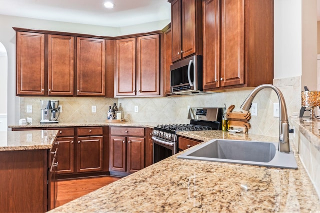 kitchen featuring light stone counters, appliances with stainless steel finishes, and sink