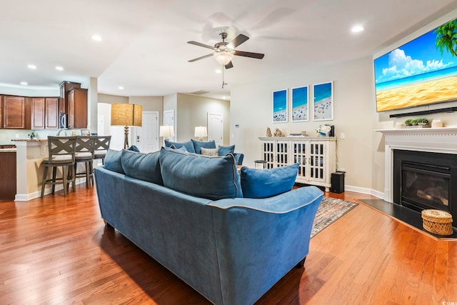 living room featuring light hardwood / wood-style flooring and ceiling fan