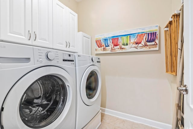 washroom with washer and clothes dryer, cabinets, and light tile patterned flooring