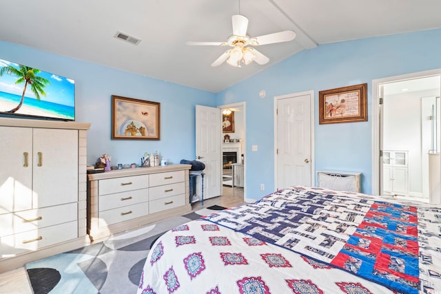 bedroom featuring lofted ceiling, ensuite bath, and ceiling fan