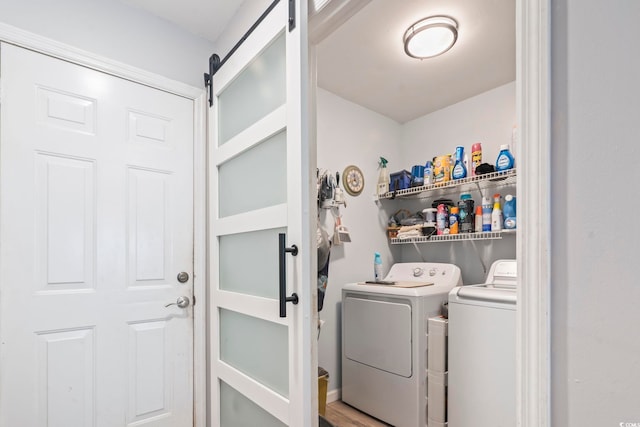 washroom featuring washing machine and dryer and a barn door