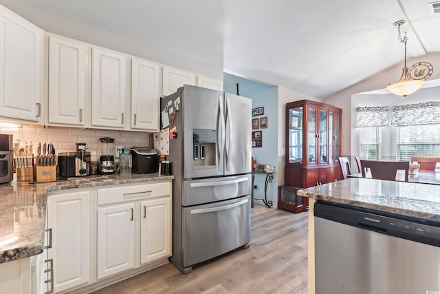 kitchen with white cabinetry, hanging light fixtures, stainless steel appliances, and lofted ceiling