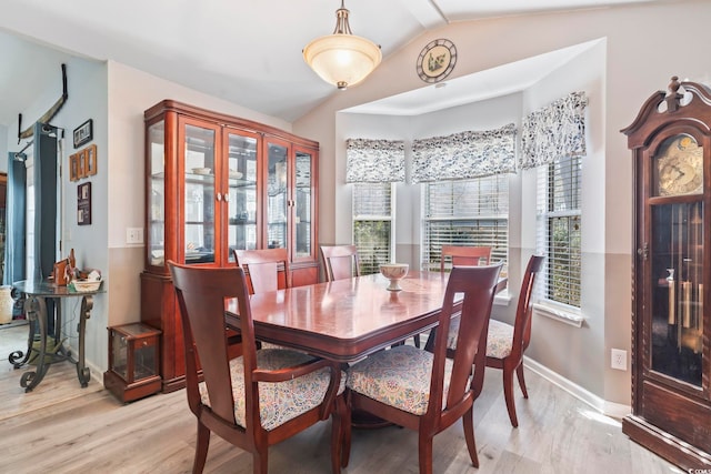 dining space featuring vaulted ceiling and light hardwood / wood-style floors