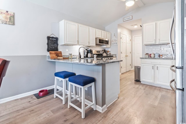 kitchen with white cabinetry, appliances with stainless steel finishes, and stone countertops