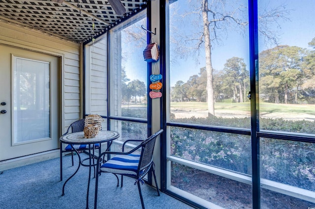 sunroom / solarium with view of scattered trees