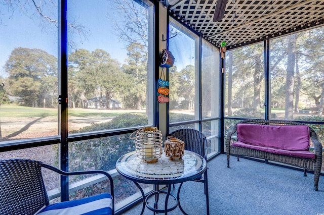 sunroom / solarium featuring view of scattered trees