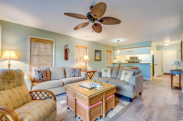 living room with light wood-style flooring and a ceiling fan