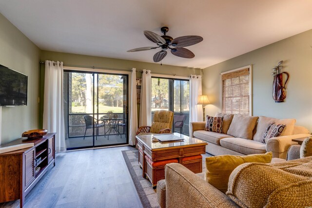 living area with wood finished floors and a ceiling fan