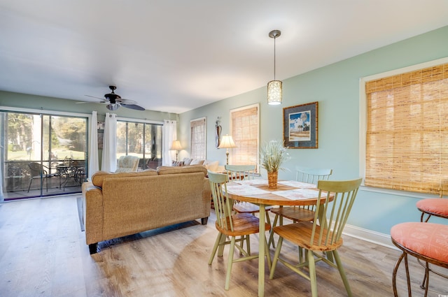 dining room with wood finished floors, baseboards, and ceiling fan