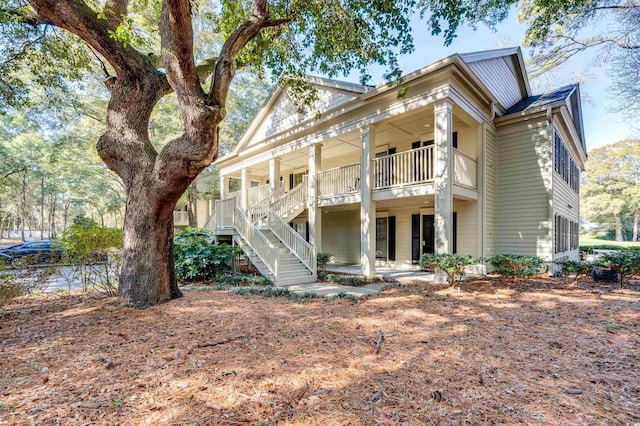 rear view of house with stairway and a porch