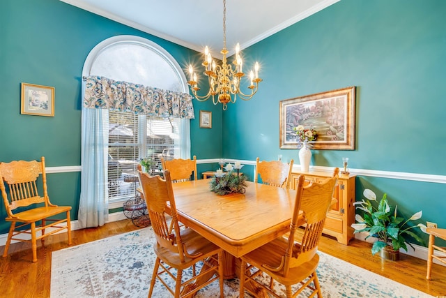 dining space featuring crown molding, a chandelier, and hardwood / wood-style floors