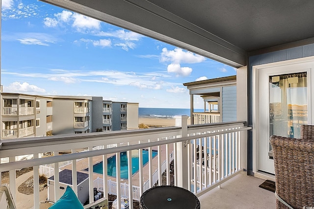 balcony featuring a view of the beach and a water view