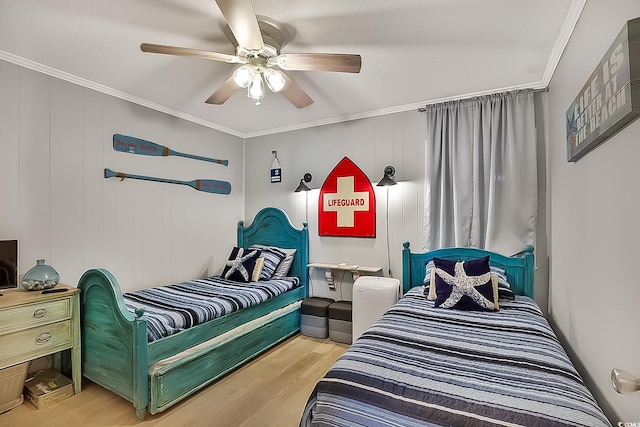 bedroom featuring ornamental molding, ceiling fan, and light wood-type flooring