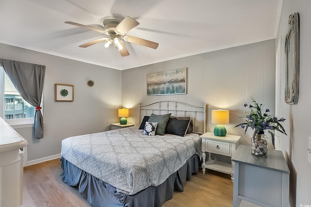 bedroom featuring crown molding, light hardwood / wood-style flooring, and ceiling fan