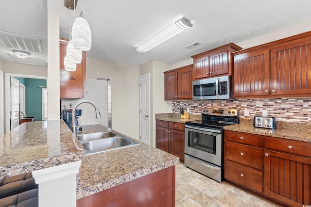 kitchen featuring visible vents, backsplash, stainless steel appliances, and a sink