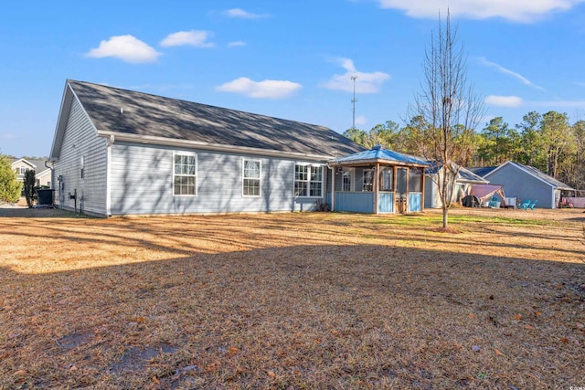 back of property featuring a yard and a sunroom