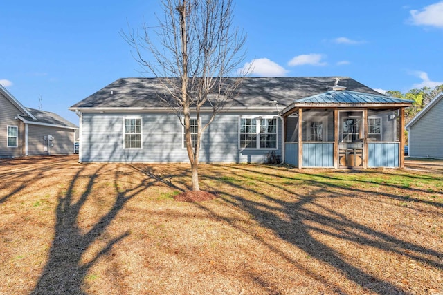 rear view of property featuring a lawn and roof with shingles