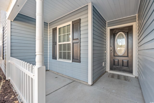 property entrance with a porch and fence