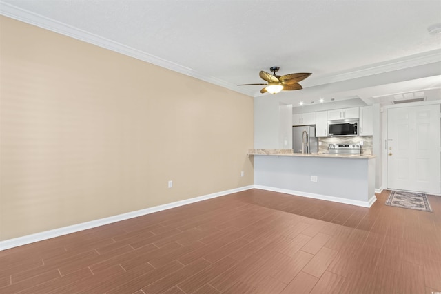 unfurnished living room featuring dark wood-type flooring, ceiling fan, and crown molding