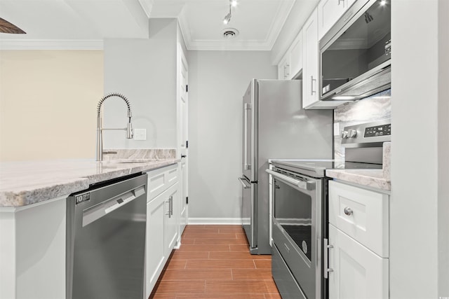 kitchen with sink, light stone counters, crown molding, appliances with stainless steel finishes, and white cabinets