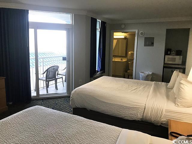 bedroom featuring access to exterior, crown molding, and ensuite bath