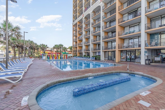 view of swimming pool with a hot tub