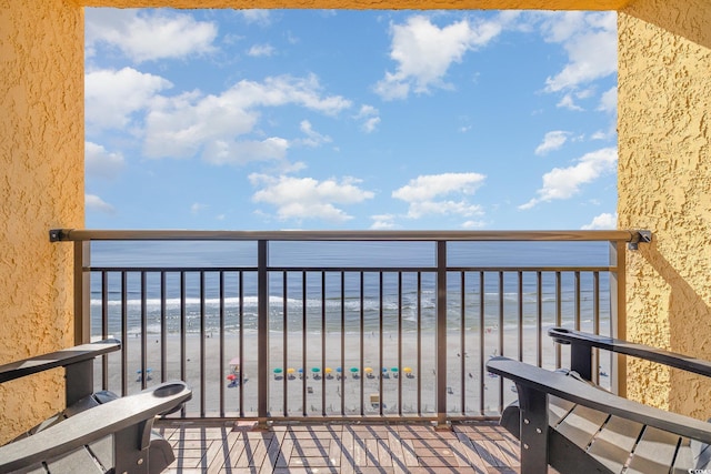 balcony featuring a water view and a beach view