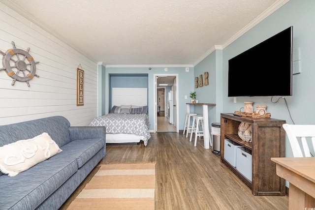 living room with hardwood / wood-style floors, ornamental molding, and a textured ceiling