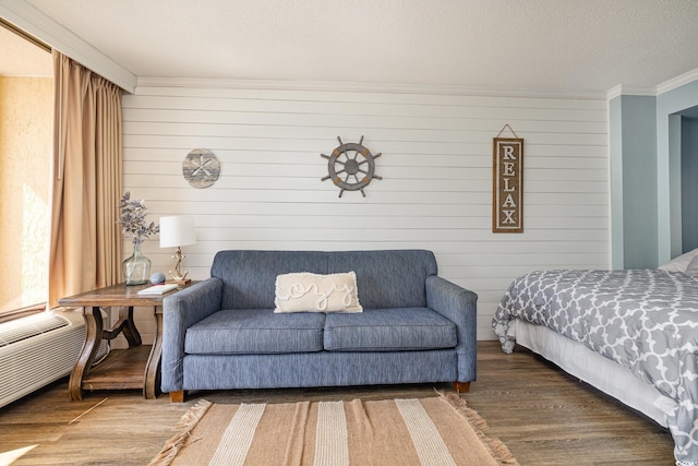 bedroom with wood-type flooring, ornamental molding, and a textured ceiling