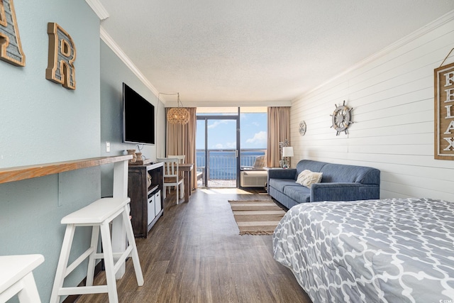 bedroom featuring ornamental molding, access to exterior, floor to ceiling windows, dark wood-type flooring, and a textured ceiling